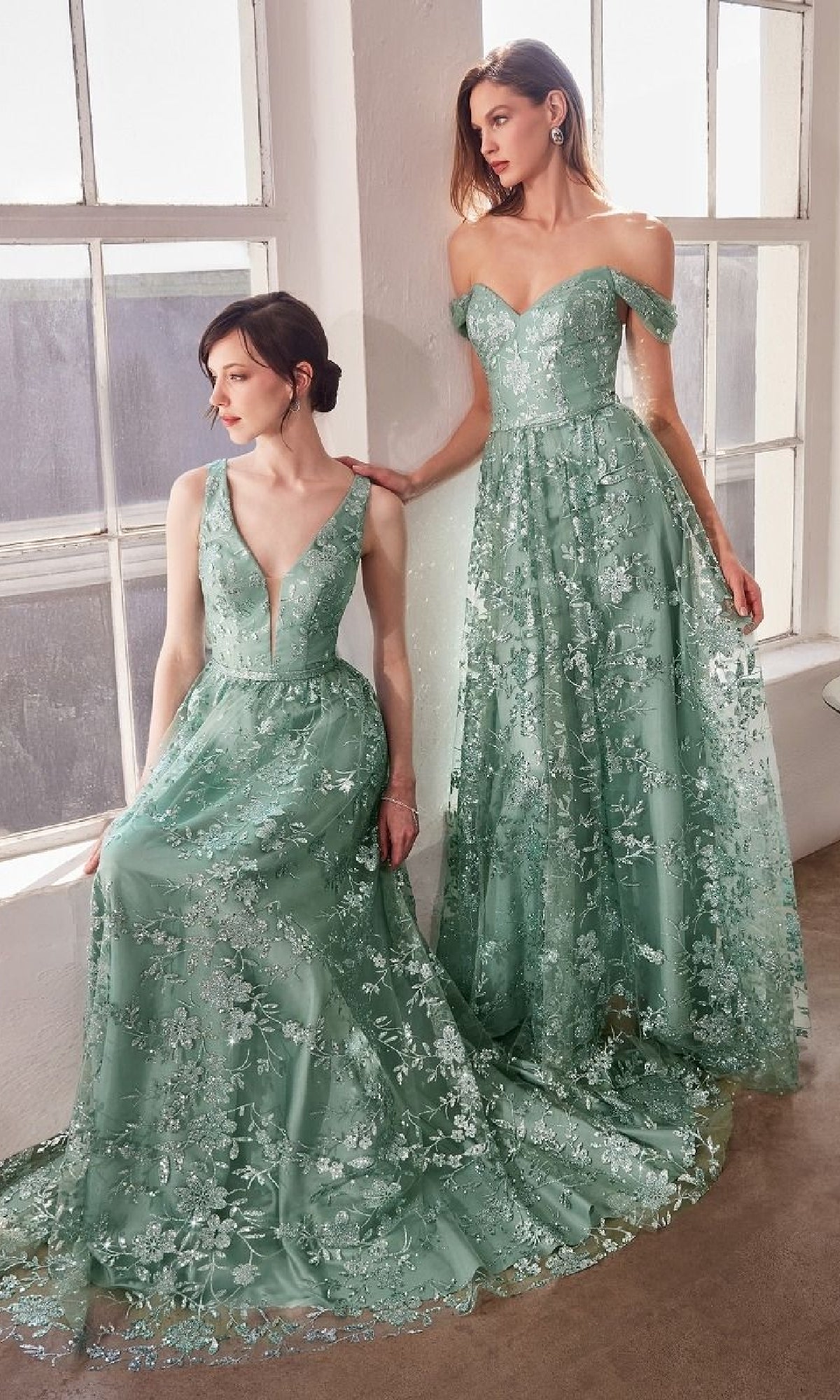 Two women showcase the Amoris T606 Embroidered-Lace Long Prom Dress in light green by large windows—one seated in a deep V-neckline, the other standing in an off-shoulder sweetheart style.